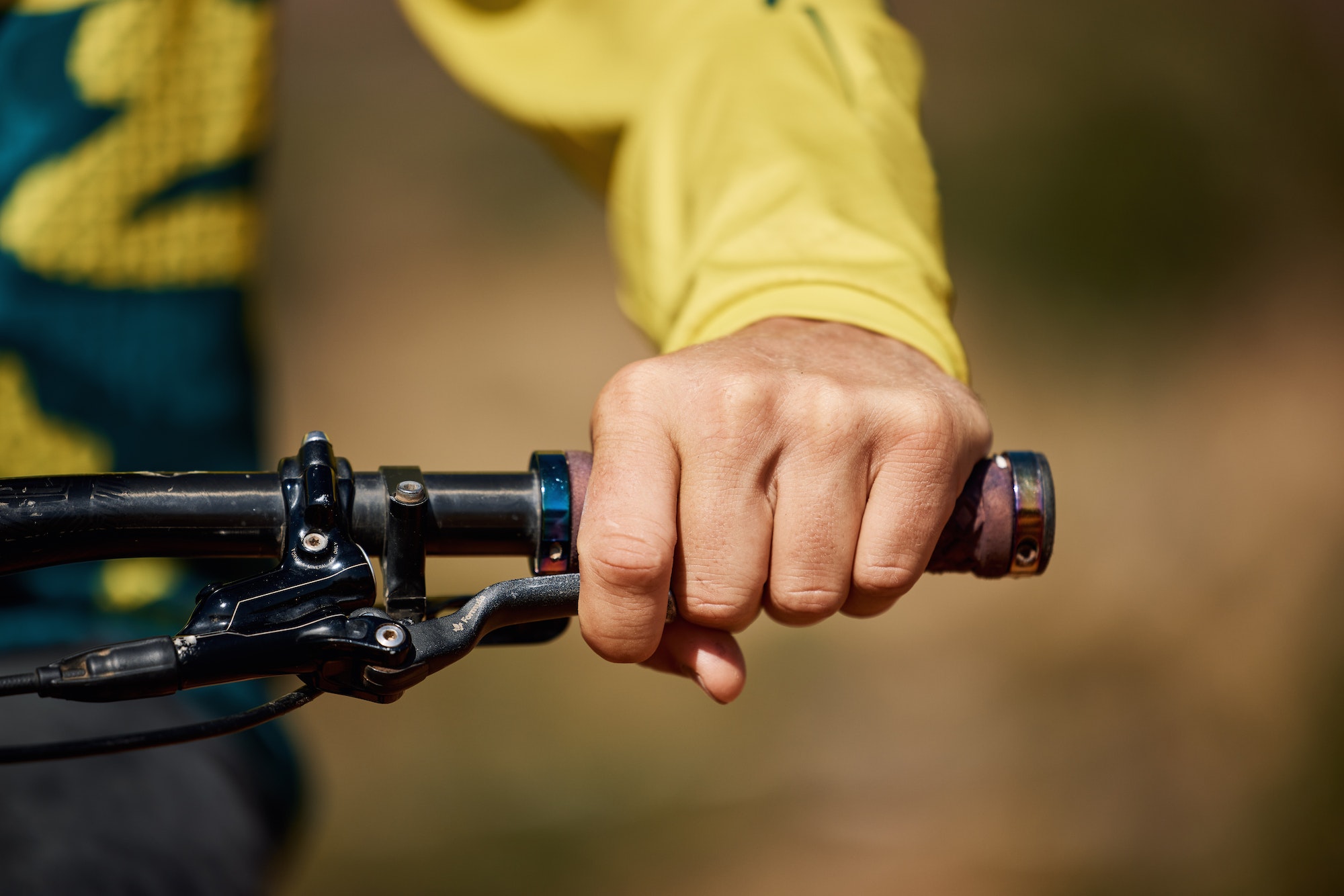 Hand, handle and bike with a man athlete or cyclist riding outdoor for fitness, exercise or cardio.